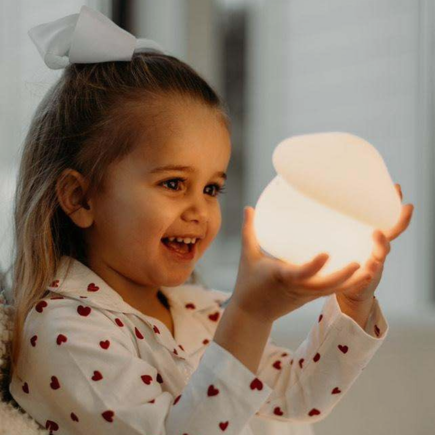 Child holding a glowing night light with a soft focus background
